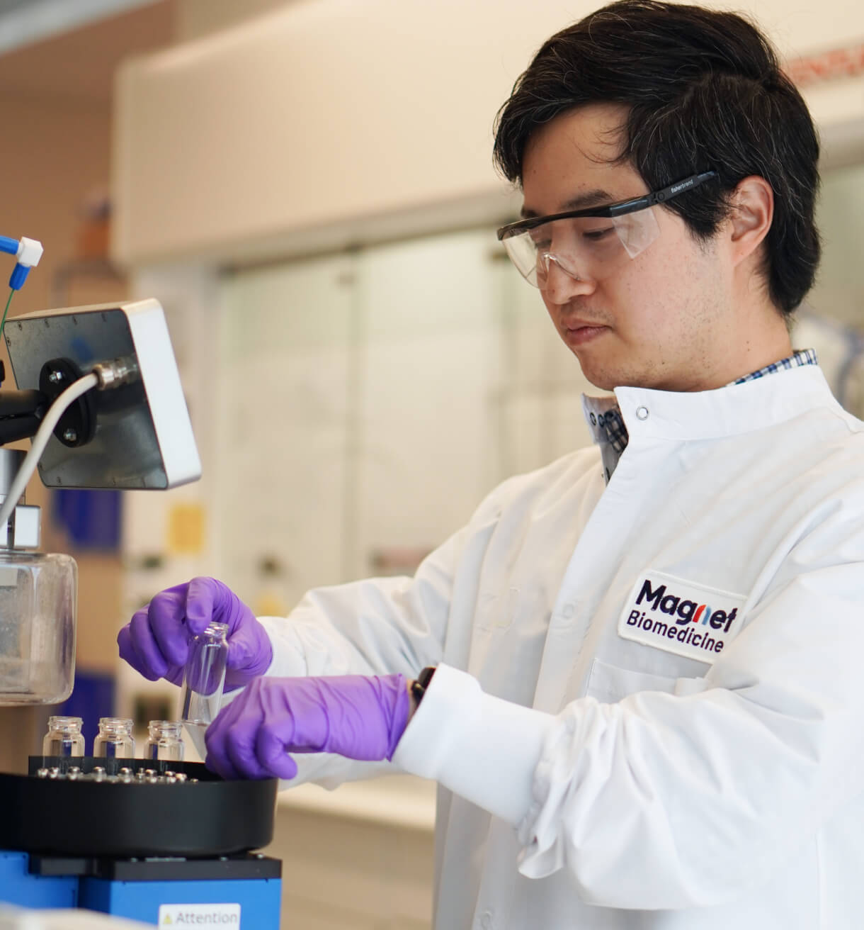 Magnet Biomedicine scientist in a lab pipetting into a conical centrifuge tube.